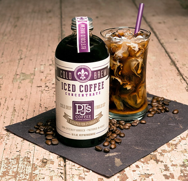 Iced Coffee Concentrate bottle shown with coffee beans on table